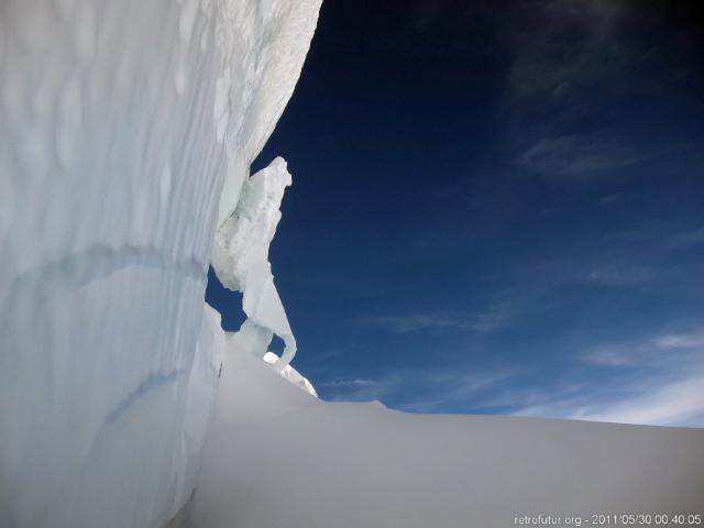 Tag 2: Aklimatisierung : Ein Wandersmann lehnt sich mit seinem schweren Rucksack an die Eiswand