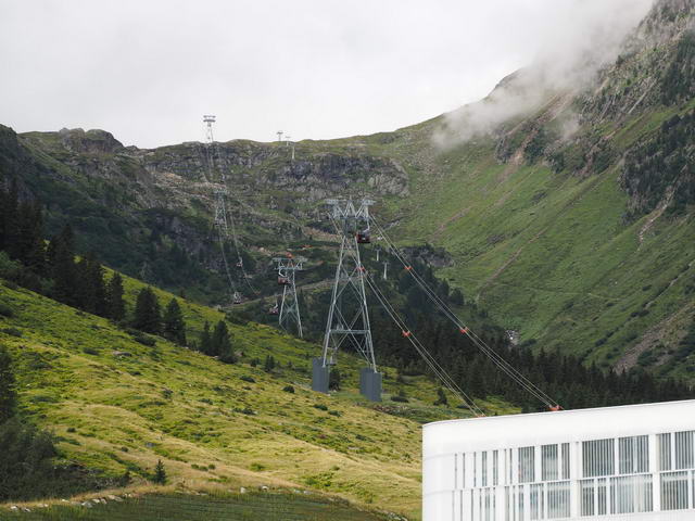 Wie aus dem Prospekt : Blick auf die Strecke (erste Sektion) der neuen 3-S Bahn. Der Höhenunterschied von 1200 Metern bei 4700 Meter Länge werden jetzt in nur 12 Minuten zurück gelegt. 64 Millionen Euro hat das Wunderwerk gekostet, entsprechend ungefähr 2.500 Mittelklasse Neuwa